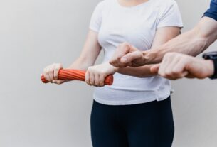 a woman holding a red handle while standing next to a man
